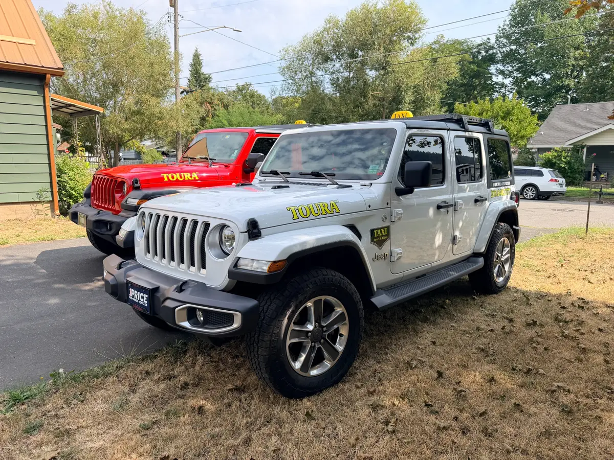 Actual TOURA white and red Jeep Wrangler taxis with company decals